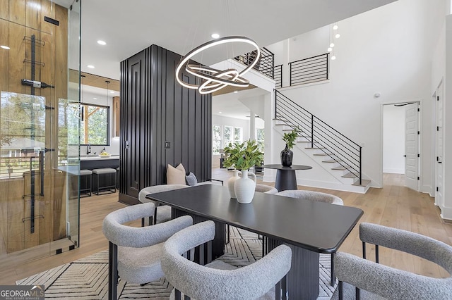 dining room with stairway, a healthy amount of sunlight, and light wood-type flooring