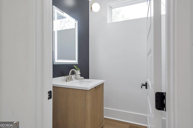 bathroom with vanity, wood finished floors, and baseboards