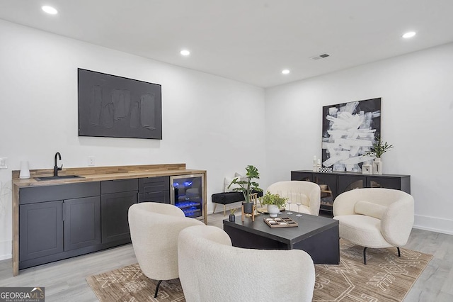 living area featuring wine cooler, recessed lighting, visible vents, and light wood finished floors