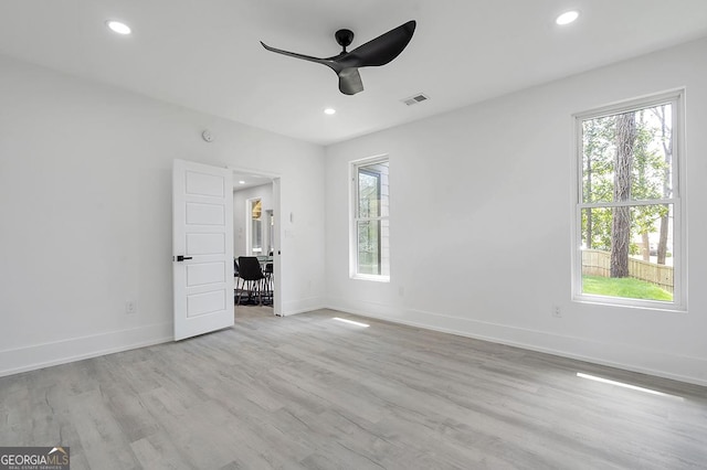 unfurnished bedroom featuring baseboards, multiple windows, and wood finished floors