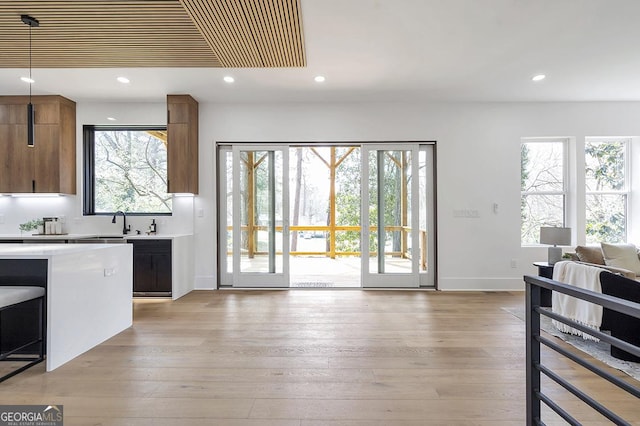 kitchen with recessed lighting, open floor plan, light wood-style flooring, and light countertops