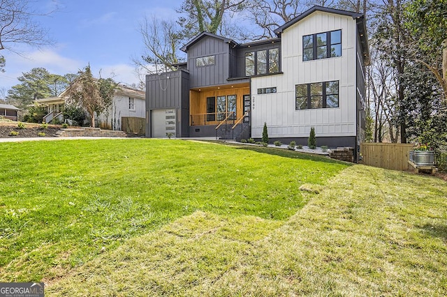 modern farmhouse with board and batten siding, a front yard, and fence