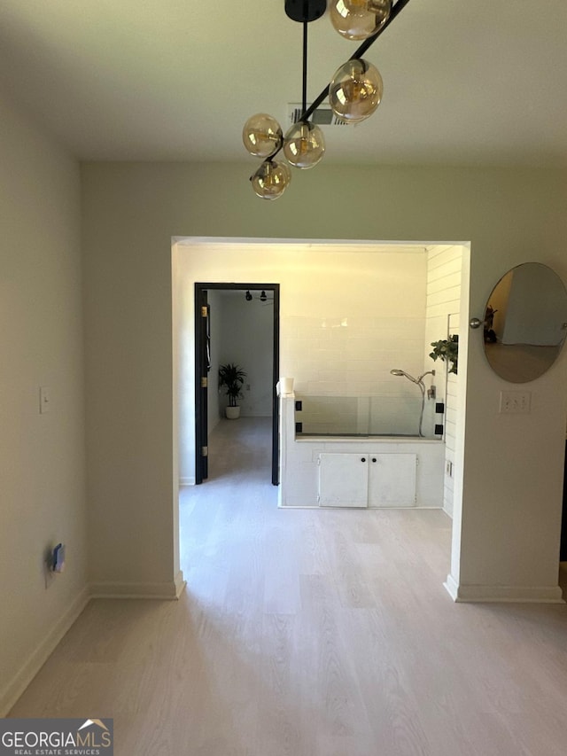 hallway with baseboards and light wood-style floors