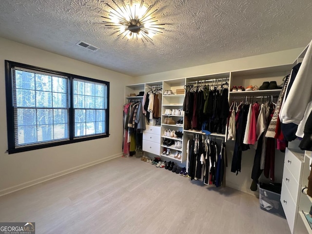 walk in closet featuring wood finished floors and visible vents