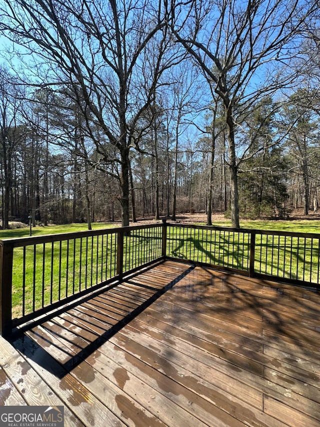 wooden deck featuring a lawn