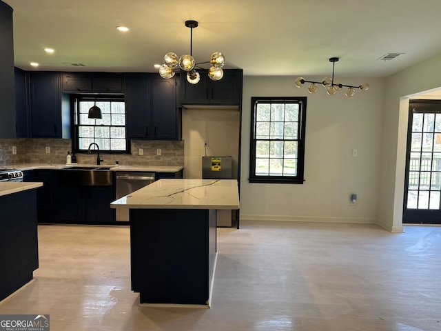 kitchen featuring visible vents, light stone counters, decorative backsplash, hanging light fixtures, and dark cabinets