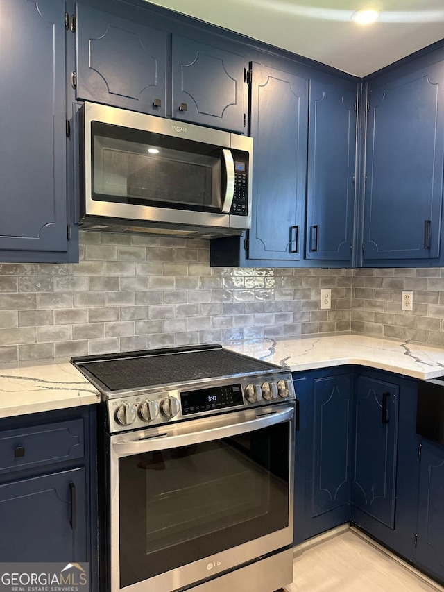 kitchen with decorative backsplash, blue cabinetry, and stainless steel appliances