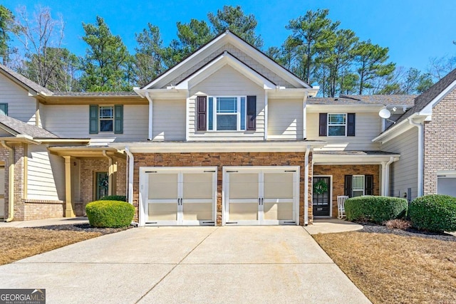 view of front of house with stone siding, an attached garage, and driveway