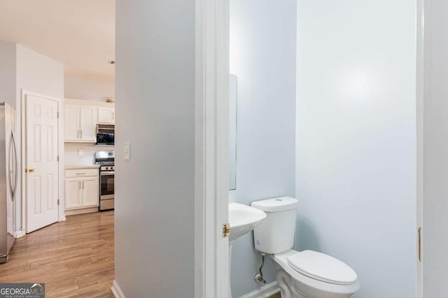 bathroom with toilet and wood finished floors