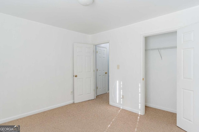 unfurnished bedroom with carpet, baseboards, and a closet