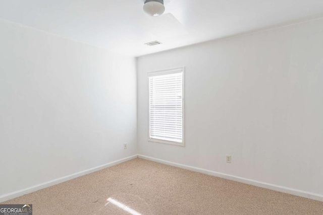 carpeted empty room with visible vents and baseboards