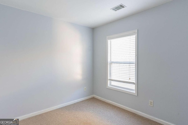 empty room with visible vents, baseboards, and light colored carpet