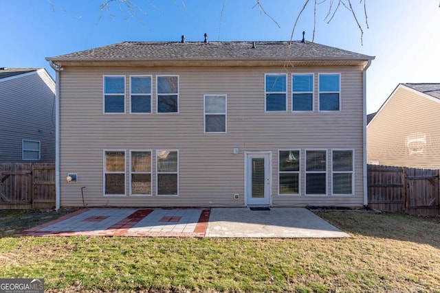 rear view of house featuring a patio, a lawn, and a fenced backyard