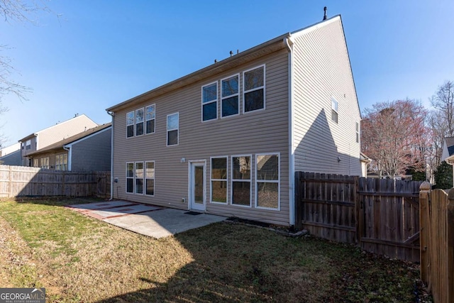 rear view of house featuring a patio, a lawn, and a fenced backyard