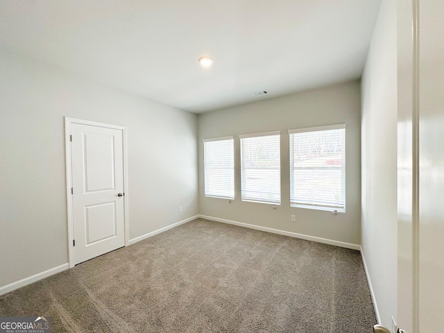 carpeted spare room with baseboards and visible vents