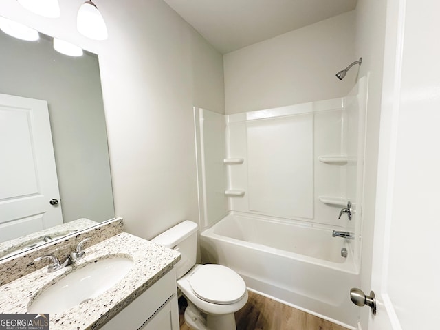 full bathroom featuring vanity, washtub / shower combination, toilet, and wood finished floors