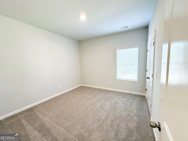 spare room featuring visible vents, baseboards, and carpet flooring