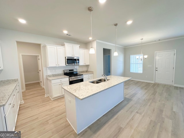 kitchen featuring visible vents, a sink, stainless steel appliances, light wood-type flooring, and backsplash