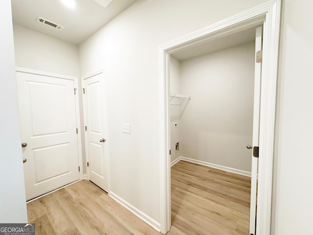 washroom with light wood finished floors, visible vents, laundry area, and baseboards