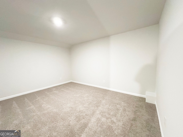 empty room featuring baseboards and carpet floors