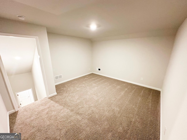 finished basement with baseboards, visible vents, and carpet floors