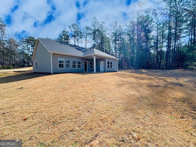 single story home with a front lawn and a shingled roof