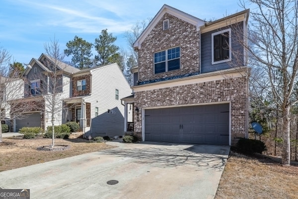 traditional-style house with a garage, brick siding, and driveway