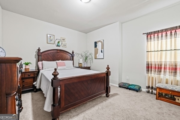 bedroom with baseboards and carpet