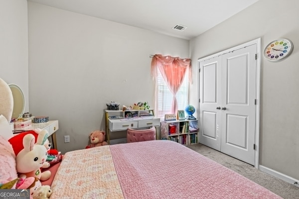 carpeted bedroom featuring baseboards and visible vents