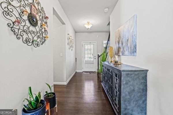 foyer entrance featuring baseboards and wood finished floors