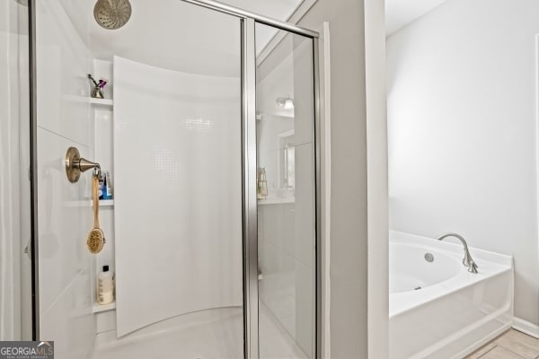 bathroom featuring a garden tub and a stall shower