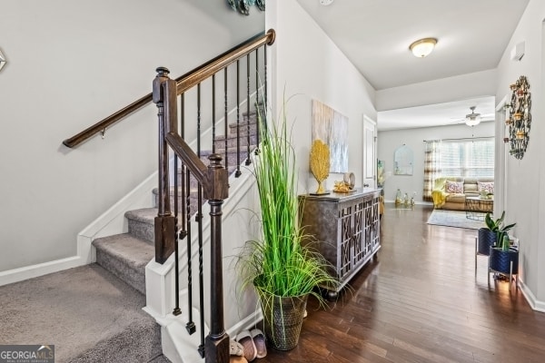 stairs with ceiling fan, baseboards, and wood finished floors