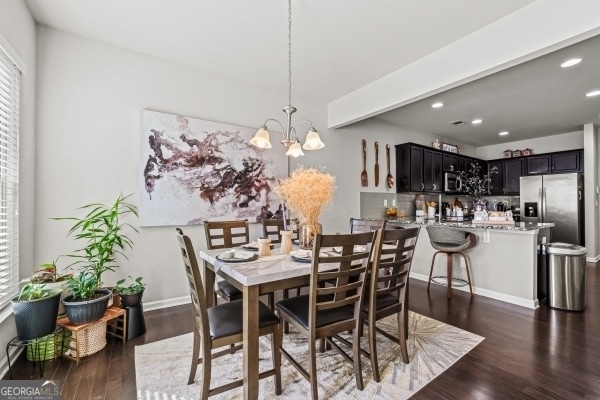 dining room featuring a notable chandelier, recessed lighting, dark wood-type flooring, and baseboards