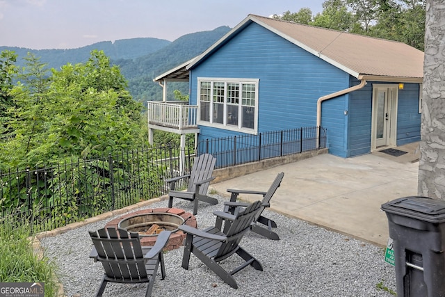 view of patio / terrace featuring a mountain view, an outdoor fire pit, and fence