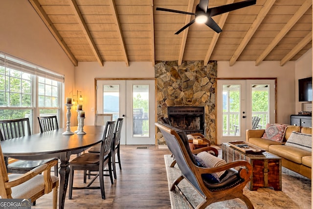 dining space with lofted ceiling with beams, french doors, wood ceiling, and a fireplace