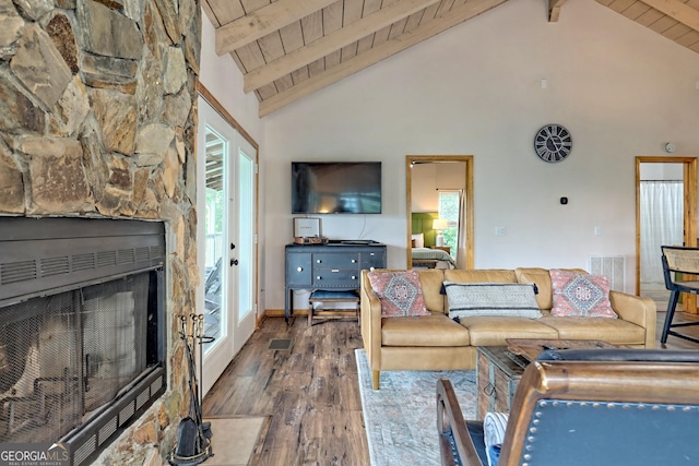 living room featuring a stone fireplace, beamed ceiling, wood finished floors, and wood ceiling