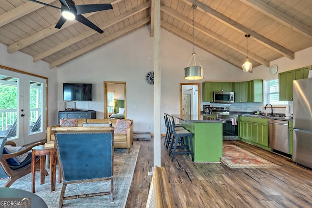 kitchen with a sink, a kitchen breakfast bar, stainless steel appliances, and green cabinetry