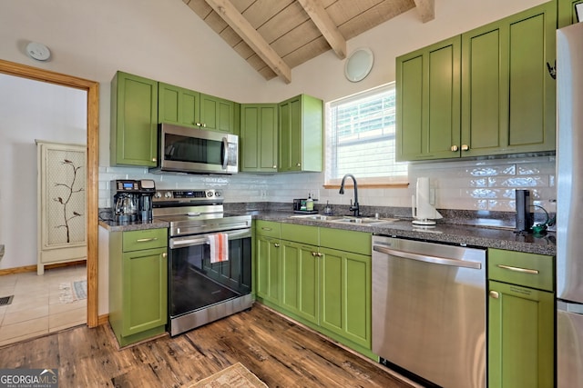 kitchen featuring a sink, stainless steel appliances, decorative backsplash, wood ceiling, and vaulted ceiling with beams