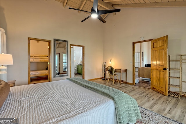 bedroom with beam ceiling, high vaulted ceiling, wood finished floors, baseboards, and wood ceiling