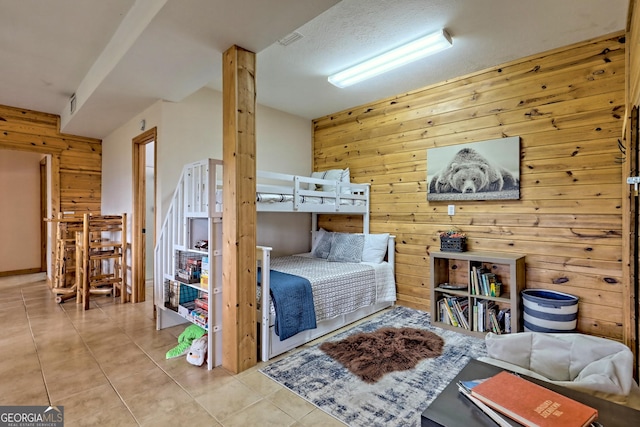 tiled bedroom with wooden walls, a textured ceiling, and visible vents