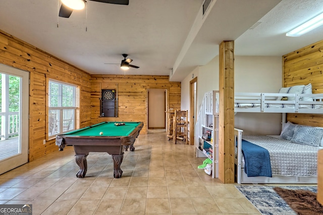 rec room with light tile patterned floors, wooden walls, ceiling fan, and billiards