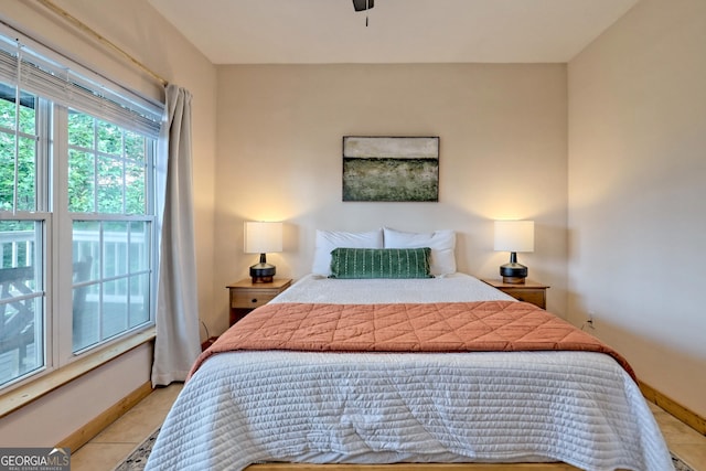 bedroom featuring light tile patterned floors and baseboards