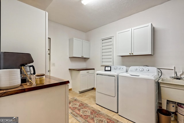 laundry room featuring cabinet space, separate washer and dryer, and light tile patterned flooring