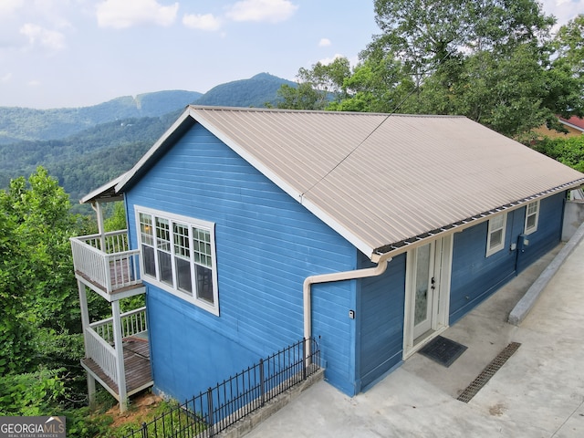 view of property exterior with a mountain view and metal roof