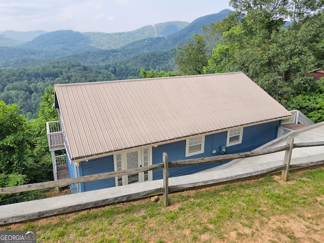 exterior space with a forest view, a mountain view, and metal roof