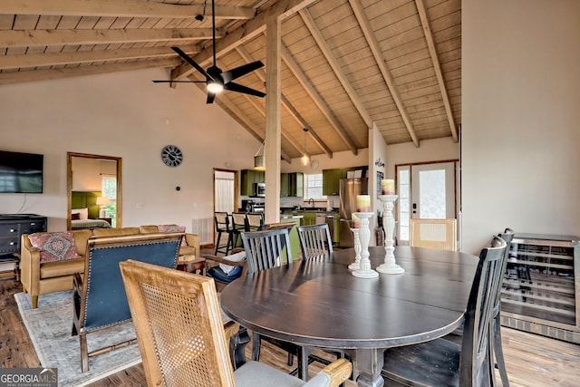 dining room featuring beamed ceiling, a healthy amount of sunlight, and light wood finished floors