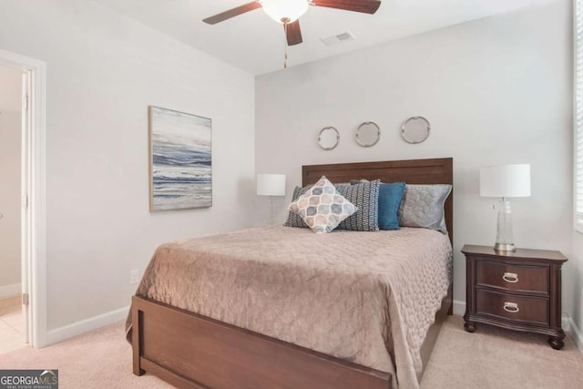 bedroom with ceiling fan, visible vents, baseboards, and light carpet