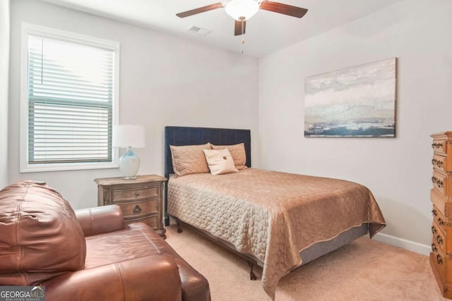 carpeted bedroom with visible vents, baseboards, and ceiling fan