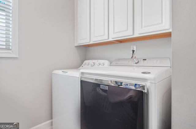 laundry room featuring cabinet space, baseboards, and washing machine and clothes dryer