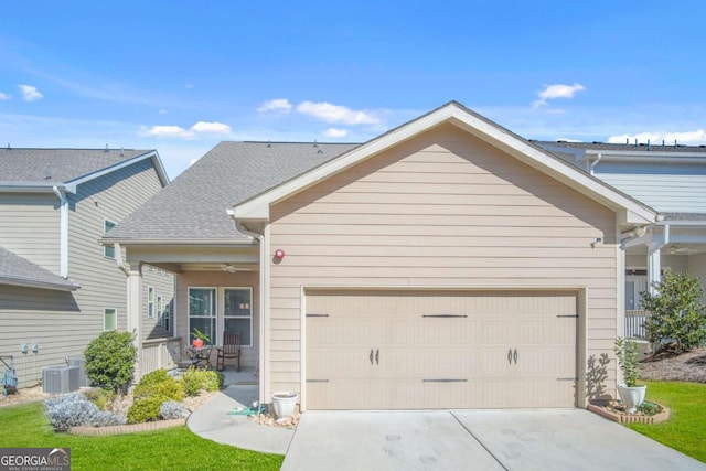 view of front of house featuring driveway, central AC, ceiling fan, a shingled roof, and a garage